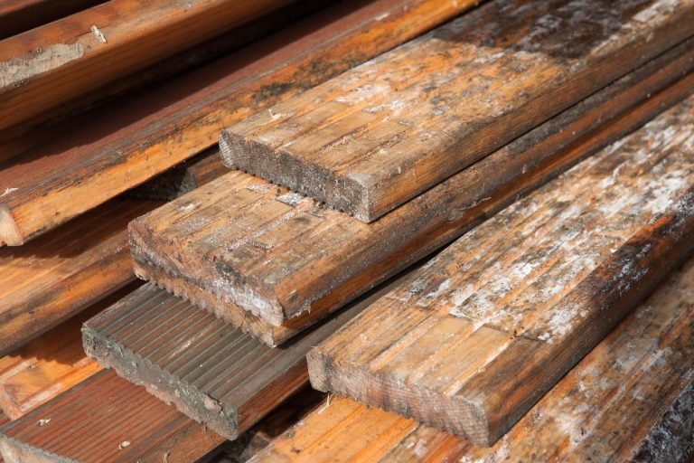 A stack of wood planks displaying signs of rust, showcasing a blend of natural texture and weathered appearance.
